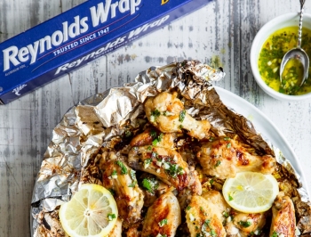 Lemon garlic chicken wings sitting on a sheet of Reynolds Wrap Heavy Duty foil