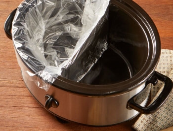 Slow cooker divided in half and one side lined with a slow cooker liner