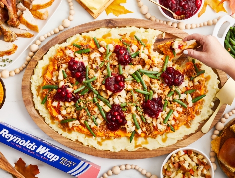 A table showing a thanksgiving spread of food. The Turkey Board shows mashed potatoes topped with green beans, turkey and cranberry. A person is dragging turkey through the board to pick up the ingredients.
