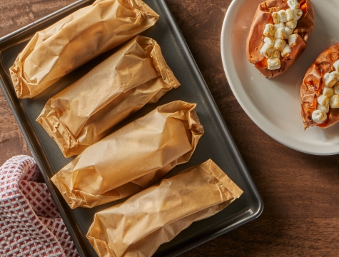 Unbleached parchment paper packets sitting on a baking sheet