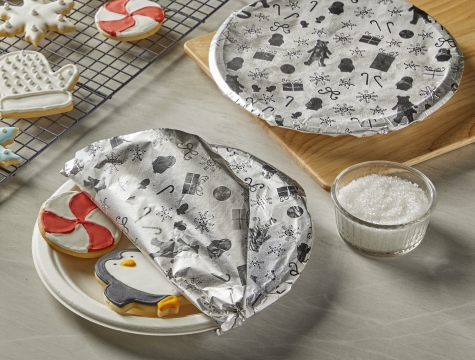 holiday decorated sugar cookies on a plate covered with aluminum foil