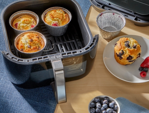 Muffins in air fryer cups sitting in an air fryer basket