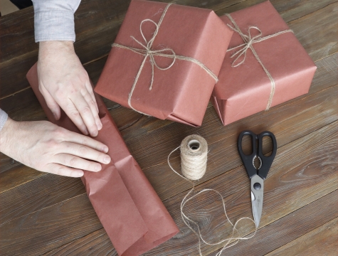 person wrapping gifts in butcher paper