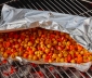 Open aluminum foil grill bag on a charcoal oven with roasted chickpeas inside