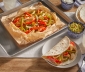 chicken fajitas sitting in an open parchment cooking bag alongside a fajita wrapped in a tortilla