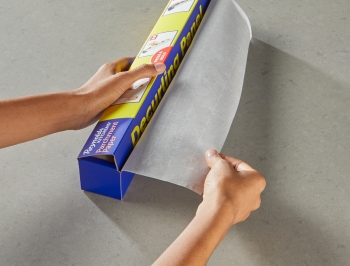 Person pulling parchment paper from box and tucking the panel into the carton