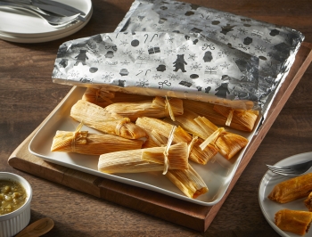 Tamales on a tray partially wrapped in aluminum foil