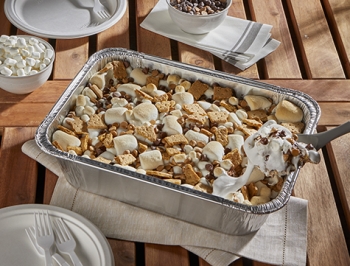 Grilled smores in a disposable pan sitting on an outdoor table