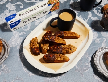 Biscotti on a plate next to a box of unbleached parchment paper