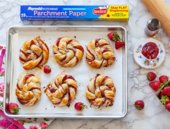 strawberry and cream rolls on a parchment lined baking sheet